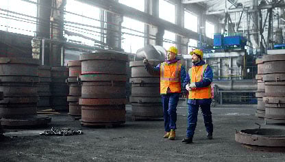 Doi inspectori mergând prin instalația industrială
